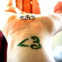 Kleines grünes Herz Tattoo am Handgelenk