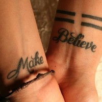 Kalligraphische Tattoo mit Worten Mach und Glaub an beiden Handgelenken