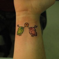 Two coloured birds inner wrist tattoo