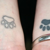 Tatuaje en dos muñecas huellas del animal