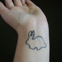 Tatuaggio delicato sul polso il coniglio bianco