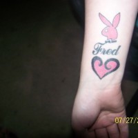 Tatuaggio sul polso il segno rosa di Playboy & il cuore rosa