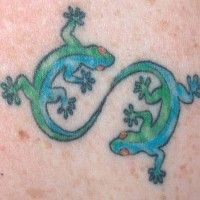 Yin and yang tattoo with green geckos