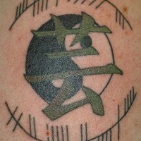 Yin yang tattoo with green hieroglyph