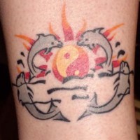 Tatuaje puesta del sol en la forma del signo yin yang con delfines