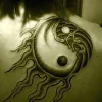 Tatuaje Yin yang con los rayos en negro y blanco en el omóplato