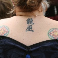 Tatuaje en la espalda, jeroglíficos y dos sellos