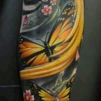 Tatuaje en el brazo, mariposas amarillos en el fondo negro