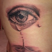 Tatuaje en las costillas de la lagrima de un ojo.
