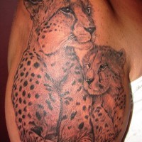 Tender gray-ink cheetah mother and baby tattoo on upper arm