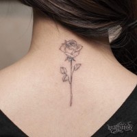 Tender pale ink rose flower detailed upper back tattoo