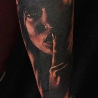 Terrifying black ink forearm tattoo of dark woman face