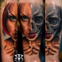 Terrifying colored horror style forearm tattoo of half woman half skull face