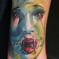 Terrifying looking colored arm tattoo of bloody monster woman