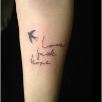 Text with a small bird tatto on arm