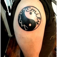 Tatuaje en el brazo, yin yang y inscripción en él