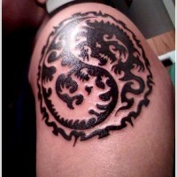 Tatuaggio sul deltoide il disegno nero in stile Yin-Yang
