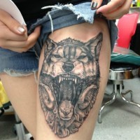 Tatuaggio sulla gamba la testa del lupo con la bocca spalancata