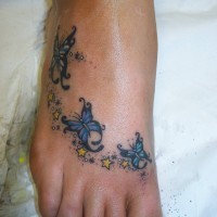 Wunderschönes Tattoo von drei blauen Schmetterlingen auf dem Fuß
