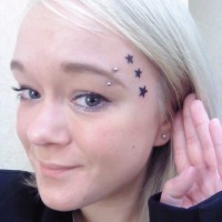 Tatuaje de tres estrellas negras en la cara