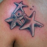 Three great gray-ink starfish tattoo on chest