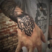 Thug Stil kleiner schwarzer Schriftzug Tattoo am Handgelenk