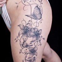 gigli tigre e farfalle tatuaggio sulla coscia femminile
