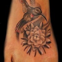 Tiny beautiful colored foot tattoo of hummingbird with flower