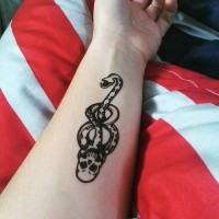 Winzige schwarze und weiße mythische Schlange mit Schädel Tattoo am Unterarm