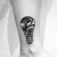 Tiny black ink ankle tattoo of bulb stylized with lighthouse and waves
