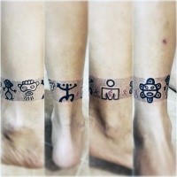 Winziges schwarzes Knöchel Tattoo mit verschiedenen Tribal Symbolen