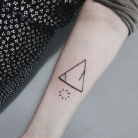 Tiny black ink mystical triangle tattoo on forearm with interesting circle shaped symbol