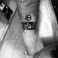 Winziges schwarzes Friedenszeichen Tattoo auf Handgelenk
