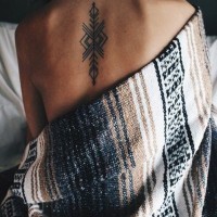 Tatuaje en la espalda alta, patrón tribal simple, tinta negra