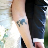 Tatuaje en el antebrazo, mapa del mundo pequeña, tinta negra