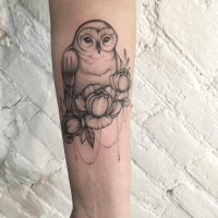 Tiny black ink sweet owl tattoo on forearm stylized with flowers