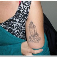 Winzige gewöhnliche betende Hände mit schwarzer TinteTattoo am Arm