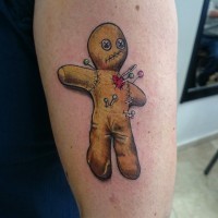 Tiny cartoon like Voodoo doll tattoo on arm