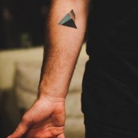 Tiny colored geometrical tattoo on arm