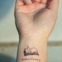 Tiny open book detailed wrist tattoo with lettering wanderer