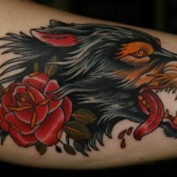 Tatuaje en el brazo,
lobo furioso con sangre y rosa, estilo viejo tradicional