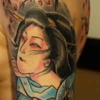 Traditional painted colored geisha tattoo on shoulder with blooming tree