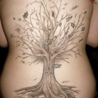 Tatuaje en la espalda, árbol seco y un signo en el tronco