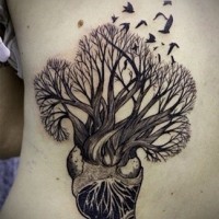 Tatuaje en las costillas, árbol crece del corazón y aves diminutas