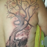 Árbol que crece hacia fuera de un tatuaje de mujer por Juliano Pereira.