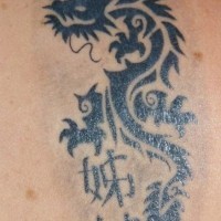 drago tribale con caratteri cinesi tatuaggio nero