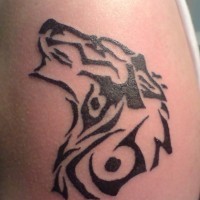 Tribal howling wolf tattoo on upper arm