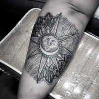Tribal style black ink sun with moon tattoo on arm