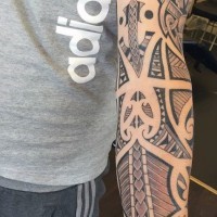 Tribal style colored original ornaments tattoo on sleeve