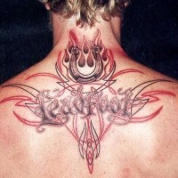 Tribal style multicolored tattoo with horseshoe and lettering on upper back